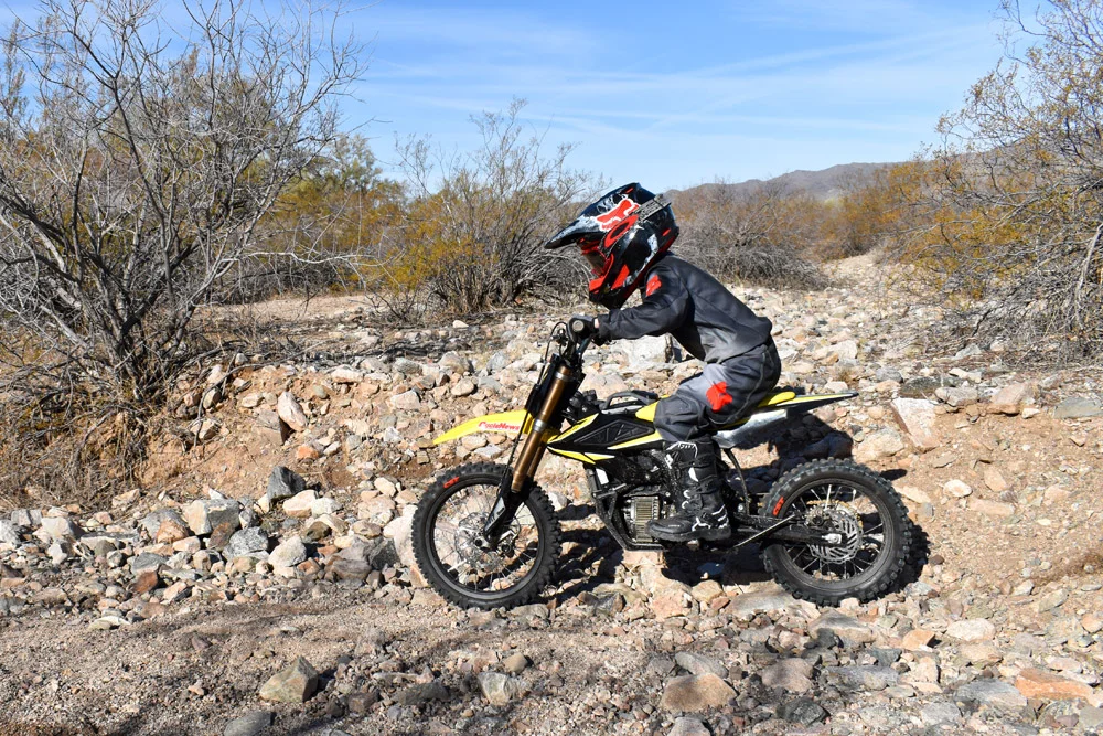 Surron Hyper Bee 2025 2025 Surron Hyper Bee electric dirt bike performing a mid-air jump on a rugged European off-road track.